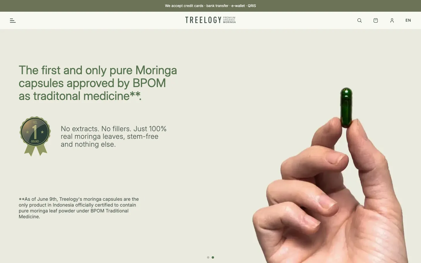 Treelogy home page with a hand holding a moringa capsule