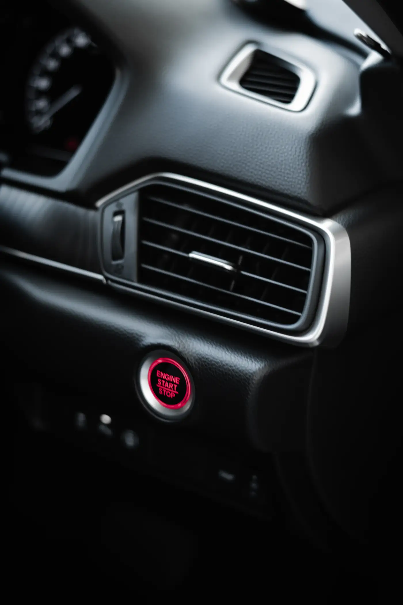 Close view of an air vent and a red start button