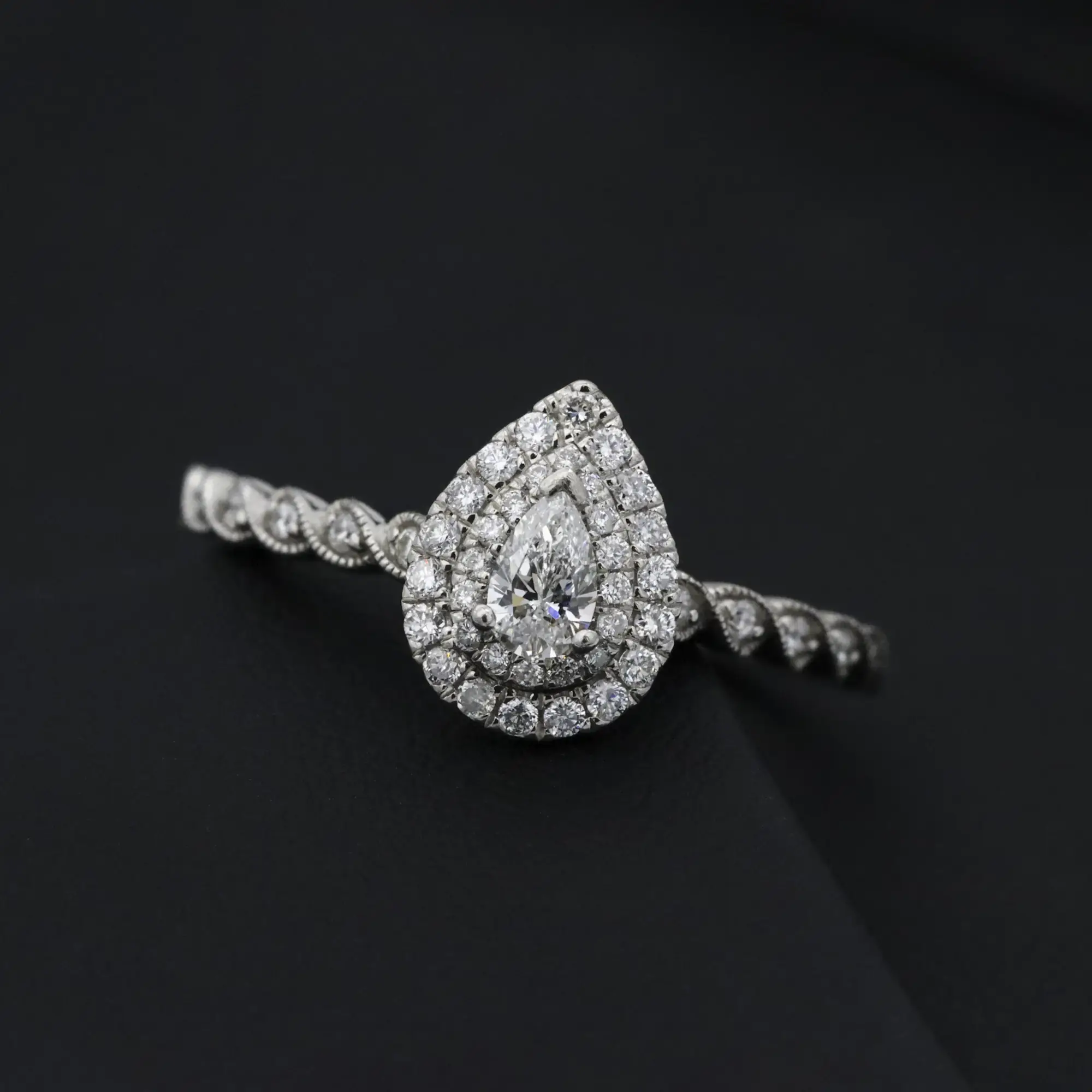 Pear cut diamond ring resting on black velvet