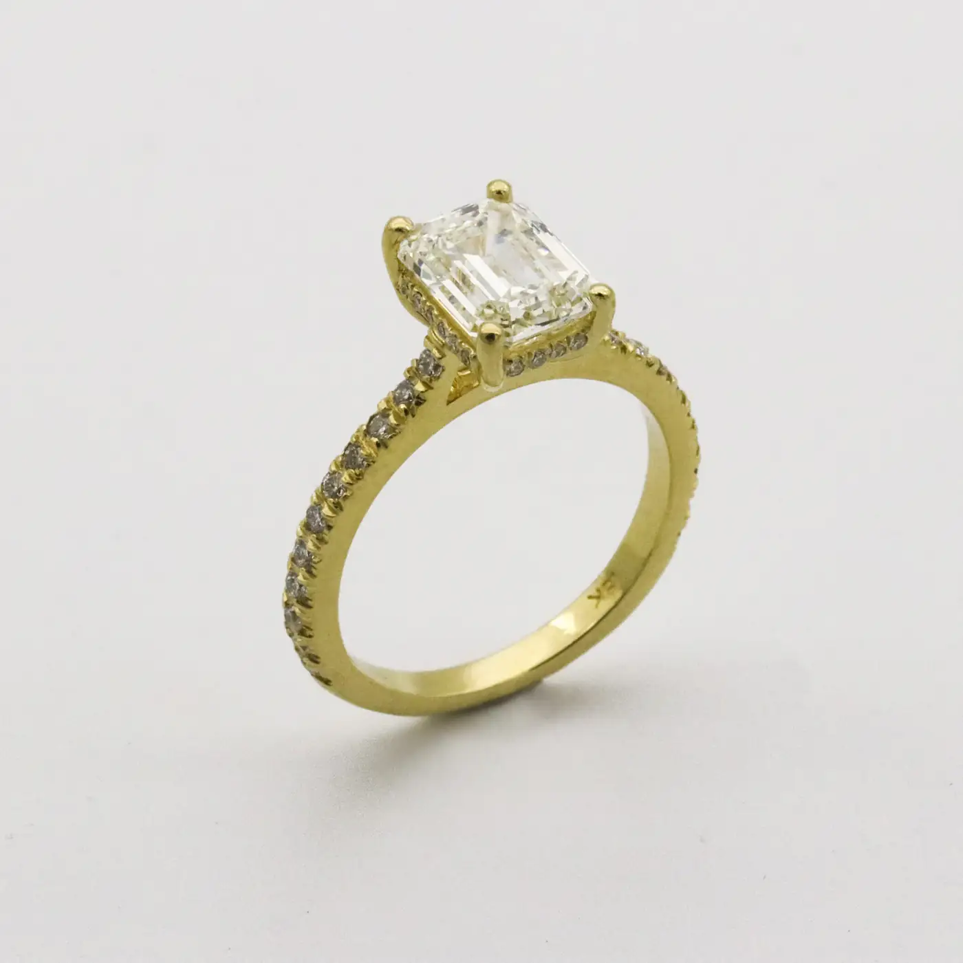 Gold solitaire ring on a white surface