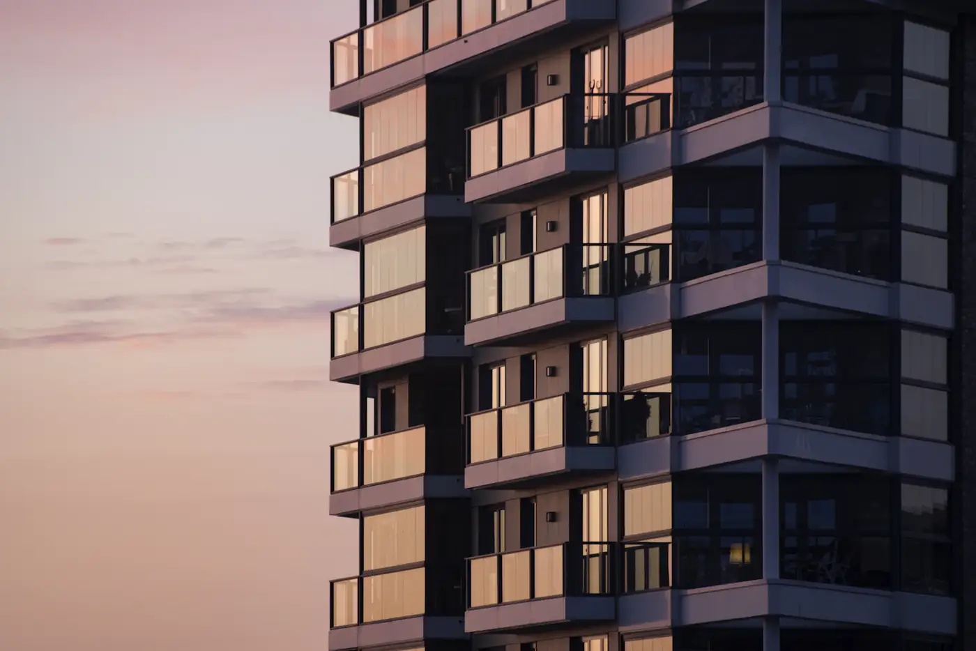Tower facade with warmly lit balconies at dusk