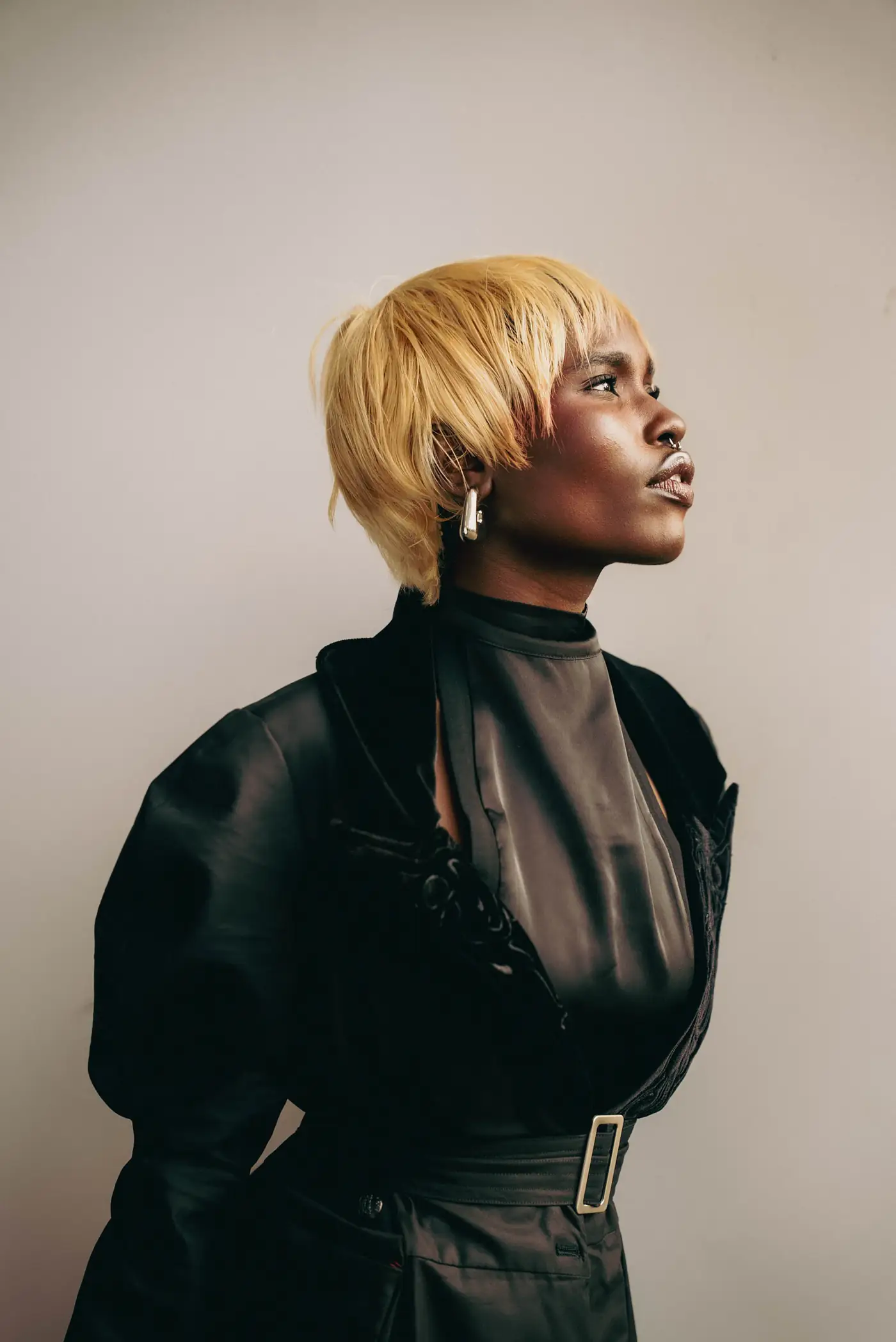 Model with a bleached bob in black, seen in profile