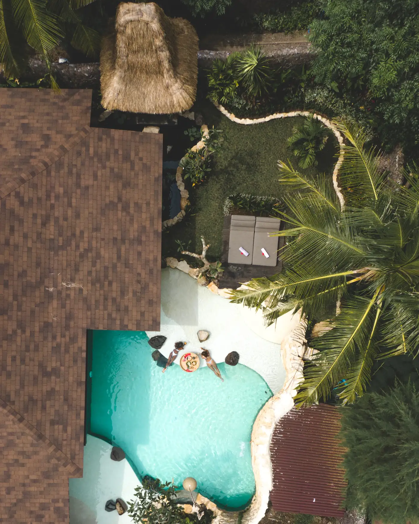 Aerial of a villa pool surrounded by jungle