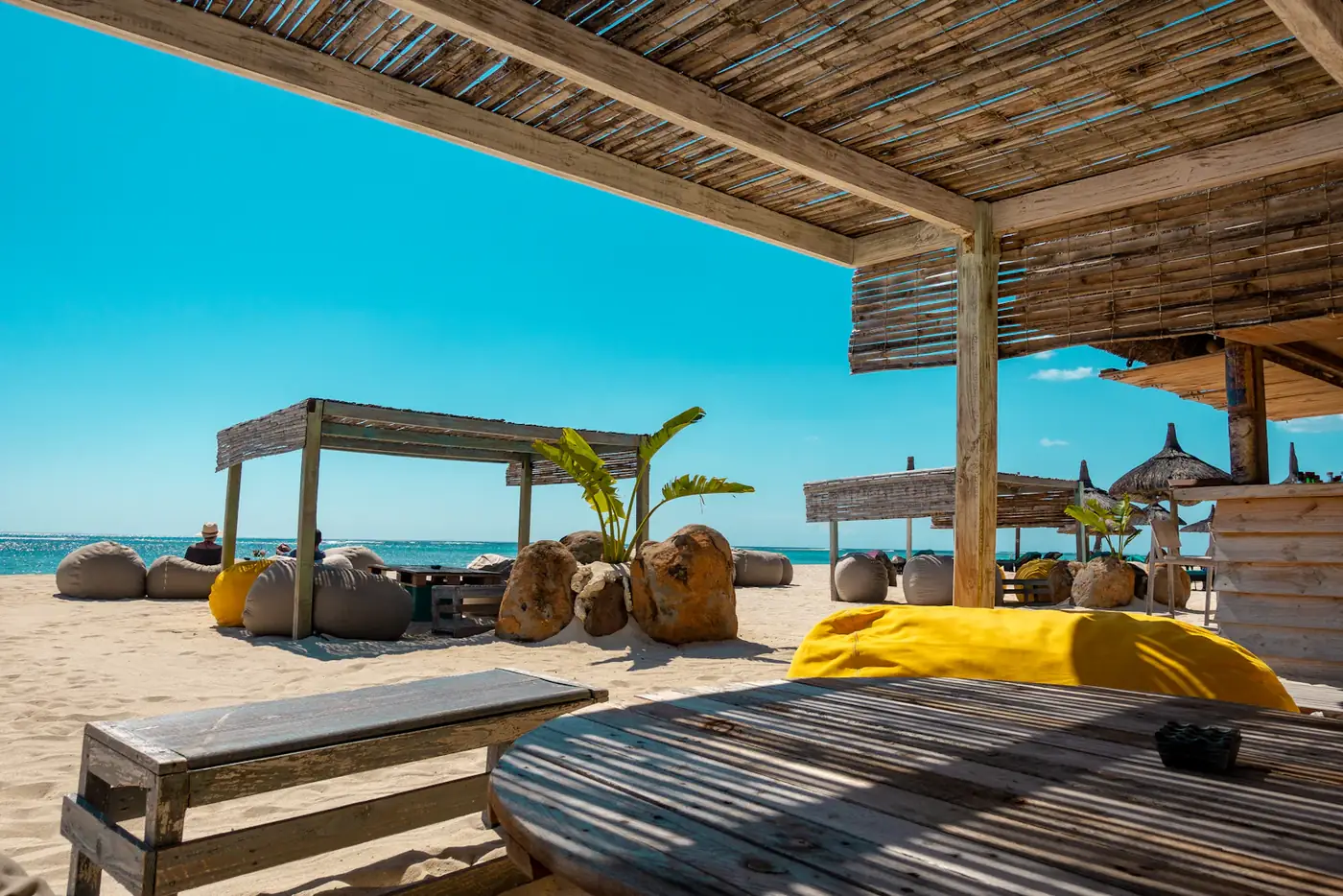 Beach cabanas with yellow cushions